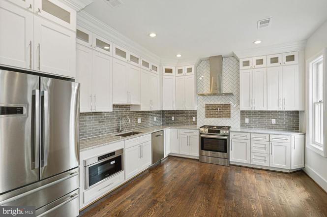 High end white kitchen with grey backsplash